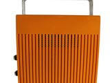 a close up of an orange radio sitting on top of a white surface