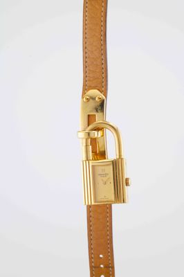 a close up of a gold watch with a padlock on it