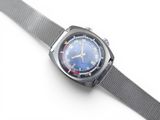 une image d'un gros plan d'une montre-bracelet sur une surface blanche