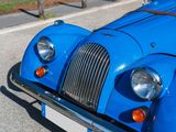 a blue vintage car parked on the side of the road