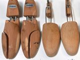four pairs of wooden shoes hang on a hook on a wall