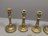 four brass candlesticks are sitting on a white table