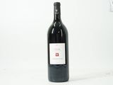 la bouteille de vin rouge est posée sur une surface blanche