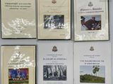 Plusieurs livres sont posés sur une table, avec un mur blanc en arrière-plan.