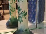 two green vases sitting on a shelf in a store