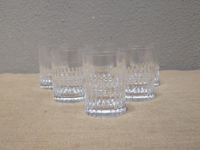quatre verres sont alignés sur une table, avec un mur en arrière-plan
