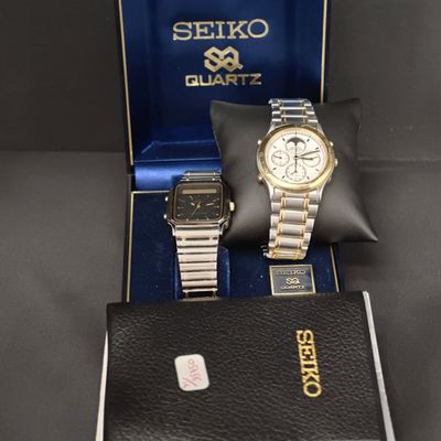 deux montres et un portefeuille posés sur une table