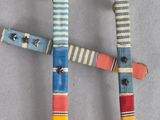 three wooden sticks with different colors and designs are arranged on a table