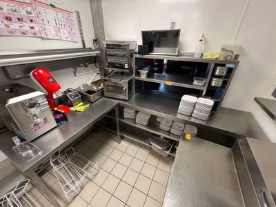 une cuisine avec beaucoup de plan de travail et une cafetière rouge