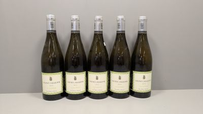 six bouteilles de vin sont alignées sur une table