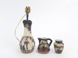 trois vases et une lampe posés sur une surface blanche
