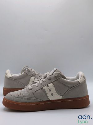 a pair of grey sneakers with brown soles on a white background