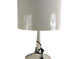 un gros plan d'une lampe posée sur une table, avec un abat-jour blanc