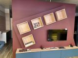 a room with a couch, a tv, and shelves on the wall