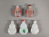 quatre petites bouteilles en verre sont alignées sur une surface grise
