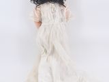 an image of a doll that is sitting down on a white surface