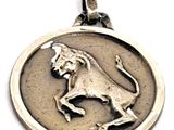 un gros plan d'un médaillon représentant un lion en argent sur fond blanc