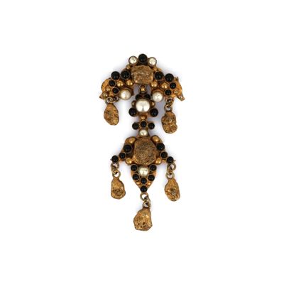 a close up of a gold and black broochle with pearls