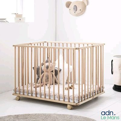 un petit berceau en bois avec une peluche à l'intérieur