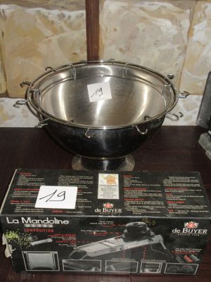 un bol en argent posé sur une table, à côté d'une boîte
