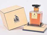 a small bottle of perfume in a box on a table