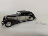 a black and silver model of a car on a white surface