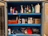 a blue cabinet filled with cleaning supplies in a bathroom