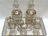 bottles and glasses on a tray with a bird on the top