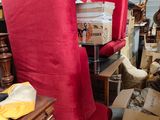 a red chair in the middle of a room filled with boxes