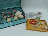 une valise contenant un plateau avec du thé et un plateau avec des tasses et des soucoupes