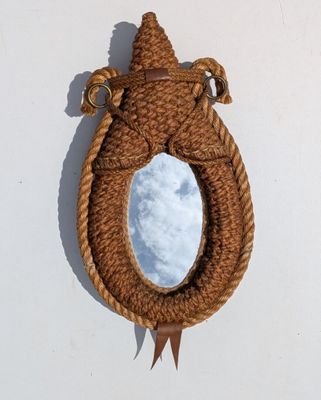 un miroir accroché au mur, avec une corde autour