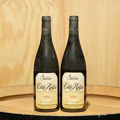 two bottles of wine sitting on top of a barrel