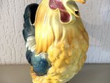 une figurine de coq jaune et noir posée sur une table