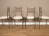 trois chaises sont alignées sur un parquet en bois dur