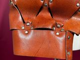 a close up of a brown leather helmet on a mannequin stand