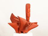 a sculpture made of red clay on a white pedestal