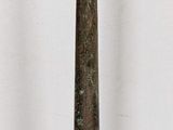 a tall metal candle holder on a white surface