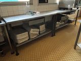 une grande cuisine avec un plan de travail en métal et une étagère en métal