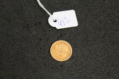 a close up of a coin on a black surface with a price tag