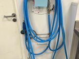 un tuyau bleu raccordé à un mur blanc