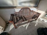 a wooden bench sitting on a tiled floor in a room