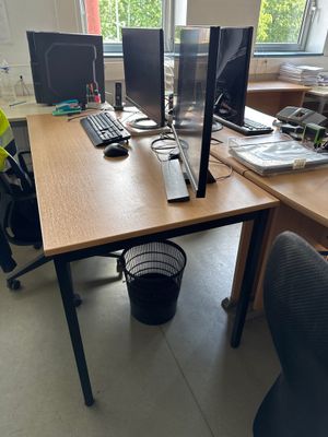 a desk with two computer monitors and a chair in front of it