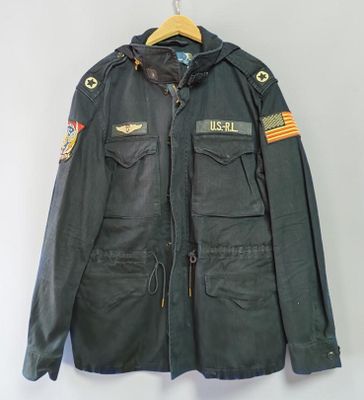 une vieille veste militaire suspendue à un cintre accroché au mur
