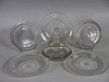 several glass plates and bowls are arranged on a white surface