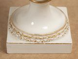 a white vase with a gold ring on top of it