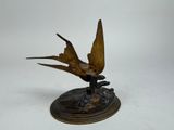a statue of a bird that is sitting on top of a base