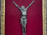 un crucifix ancien en bronze sur fond de velours rouge