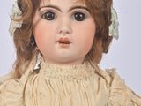 an old fashioned doll with red hair and a white dress