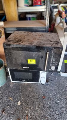 un micro-ondes posé par terre à côté d'autres appareils électroménagers