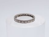 a close up of a ring with diamonds on a white surface